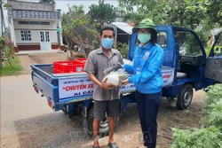 Trao các phần cho người dân có hoàn cảnh khó khăn. Ảnh: Nhật Bình - TTXVN. 