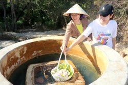 Du khách thích thú tự tay luộc trứng tại giếng nước nóng tự nhiên đổ ra Suối nước nóng Bưng Thị, huyện Hàm Thuận Nam (tỉnh Bình Thuận). Ảnh: Nguyễn Thanh - TTXVN