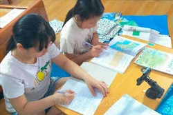 Hầu hết sách giáo khoa từ các nhà trường đã được chuyển tới học sinh trước ngày khai giảng nên học sinh yên tâm đủ sách để học trực tuyến tại nhà. Ảnh: TTXVN phát 