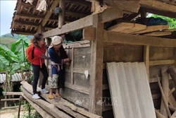 Du khách thích thú khám phá kho thóc của người Dao Tiền ở xóm Hoài Khao. Ảnh: Quốc Đạt - TTXVN