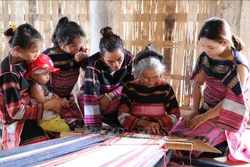 Nghệ nhân Đinh Thị Puốt, 80 tuổi, làng dệt Pơ Nang, xã Tú An, thị xã An Khê (Gia Lai) truyền dạy nghề cho thế hệ con cháu. Ảnh: Hồng Điệp - TTXVN