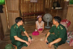 Cán bộ Đồn Biên phòng Bản Giàng thường xuyên đến nhà các hộ dân dạy bà con về phát triển kinh tế, cách phòng bệnh. Ảnh: Hoàng Ngà - TTXVN