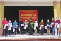 Trao giấy chứng nhận hoàn thành cách ly tập trung cho các công dân về từ Cộng hòa Nam Phi. Ảnh: Đinh Tuấn - TTXVN