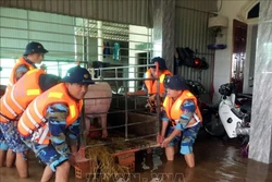 Cán bộ, chiến sĩ Hải đội 102 giúp bà con dọn dẹp nhà cửa khi nước rút. Ảnh: TTXVN