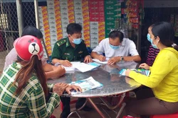 Bô đội Biên phòng tuyên truyền đến từng nhà dân cam kết thực hiện nghiêm khuyến cáo 5K của Bộ Y tế và không xuất nhập cảnh trái phép vực biên giới biển Sóc Trăng. Ảnh: Trung Hiếu - TTXVN