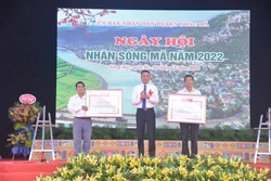 Phó Chủ tịch Ủy ban nhân dân tỉnh Sơn La Nguyễn Thành Công trao quyết định của Chủ tịch Ủy ban nhân tỉnh công nhận làng nghề chế biến long nhãn cho bản Hải Sơn và bản Hồng Nam của xã Chiềng Khoong, huyện Sông Mã. Ảnh: Quang Quyết-TTXVN 