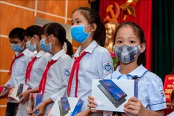 Các em học sinh huyện Ba Vì nhận những chiếc máy tính bảng từ các nhà hảo tâm. Ảnh: Trần Việt - TTXVN 
