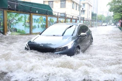 Mưa bão gây ngập úng ảnh hưởng đến việc di chuyển của người dân. Ảnh: Hoàng Hiếu - TTXVN 