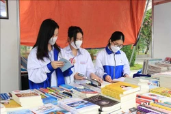 Các em học sinh đọc sách tại Ngày sách. Ảnh: Thái Hùng - TTXVN 