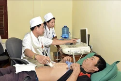 Bác sĩ trẻ tại Bệnh viện Đa khoa huyện Sốp Cộp, tỉnh Sơn La ứng dụng kỹ thuật mới để thăm khám cho bệnh nhân. Ảnh: Hữu Quyết - TTXVN