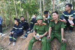 Các lực lượng tham gia chữa cháy nghỉ ngơi sau một đêm thức trắng. Ảnh: Hoàng Ngà - TTXVN