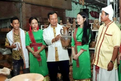 Anh Đàng Chí Quyết giới thiệu với du khách về gốm truyền thống của làng nghề. Ảnh: TTXVN phát 