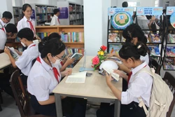 Các học sinh đọc sách tại Ngày hội. Ảnh: Hồng Hiếu - TTXVN 