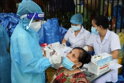 Lấy mẫu test nhanh cho người dân đến nhận quà hỗ trợ tại "Chợ nhân đạo". Ảnh: Thanh Tùng -TTXVN 