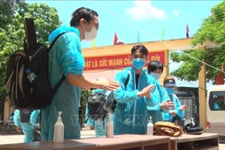 Các công dân tiến hành sát khuẩn khi vừa đến khu cách ly của Trung đoàn Bộ binh 126. Ảnh: Đinh Tuấn - TTXVN