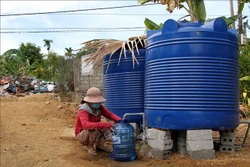 Người dân xã Mai Hóa huyện Tuyên Hóa, tỉnh Quảng Bình phấn khởi khi được sử dụng nước miễn phí tại một điểm cấp nước. Ảnh: Văn Tý-TTXVN 