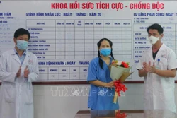 Lãnh đạo Bệnh viện Đà Nẵng trao hoa chúc mừng bệnh nhân. Ảnh: TTXVN