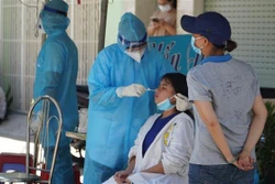 Lực lượng y tế tiến hành lấy mẫu xét nghiệm người dân nơi bị phong tỏa. Ảnh: TTXVN phát 