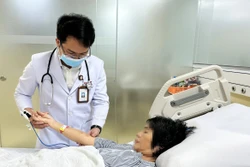 Bác sĩ Bệnh viện Đa khoa Thanh Vũ Medic Bạc Liêu kiểm tra vết ong đốt trên tay bệnh nhân T.H.C. Ảnh: TTXVN phát