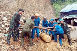 Ban Chỉ huy Quân sự huyện Tương Dương, lực lượng Dân quân xã Xá Lượng tiến hành trục vớt, vận chuyển quả bom đến khu vực hủy nổ. Ảnh: TTXVN phát