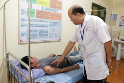 Bác sĩ Bệnh viện Đa khoa huyện Mường La, tỉnh Sơn La, khám bệnh cho bệnh nhân có thẻ bảo hiểm y tế. Ảnh: Hữu Quyết - TTXVN
