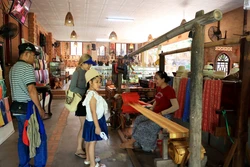 Khách du lịch tham quan, tìm hiểu nghề dệt thổ cẩm Chăm trong khu di tích tháp Pô Sah Inư, phường Phú Hài, thành phố Phan Thiết. Ảnh: Hồng Đạt – TTXVN