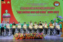 Ban Tổ chức trao Giấy khen của Hội Khuyến học tỉnh Sơn La và xe đạp cho các em học sinh. Ảnh: Quang Quyết - TTXVN