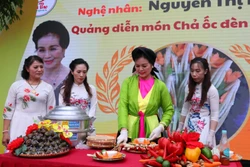 Nghệ nhân Nguyễn Thị Hiền quảng diễn món Chả ốc đèn lồng tiến Vua tại Liên hoan. Ảnh: Trung Kiên - TTXVN