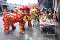 Đội lân sư rồng thuộc đoàn rước ghé vào các mâm lễ của các gia đình hai bên đường chúc làm ăn đắc lộc trong những ngày diễn ra lễ hội truyền thống đền Kỳ Cùng - Tả Phủ. Ảnh: Anh Tuấn – TTXVN