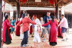 Du khách quốc tế cùng các nghệ nhân và người dân tham gia Hát Xoan tại đình cổ Hùng Lô (xã Hùng Lô, thành phố Việt Trì, tỉnh Phú Thọ). Ảnh: Trung Kiên - TTXVN