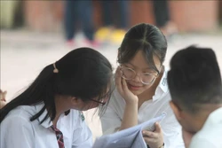 Thí sinh tranh thủ ôn lại kiến thức trước khi vào phòng thi. Ảnh: Thanh Tùng – TTXVN
