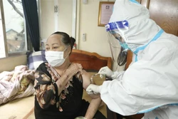 Nhân viên y tế phường Cửa Đông (quận Hoàn Kiếm) tiêm cho người cao tuổi tại nhà. Ảnh: Minh Quyết - TTXVN 