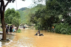 Một người dân cố đi xe qua chỗ ngập nhưng đã phải quay lại. Ảnh: Tuấn Anh - TTXVN