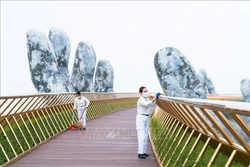Lau dọn làm vệ sinh khử khuẩn cầu Vàng để chuẩn bị đón khách du lịch trở lại. Ảnh: TTXVN phát