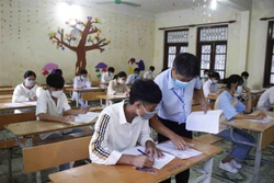 Giám thị hướng dẫn cho thí sinh điền thông tin cá nhân vào bài thi tại điểm thi Trường THPT huyện Phong Thổ, Lai Châu. Ảnh: Đinh Thùy-TTXVN