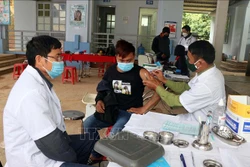 Cán bộ quân y Đồn Biên phòng Mường Cai, Bộ Chỉ huy Bộ đội Biên phòng Sơn La, tham gia tiêm vaccine COVID-19 cho người dân vùng biên huyện Sông Mã. Ảnh: Hữu Quyết - TTXVN