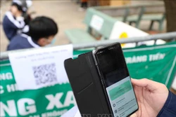 Học sinh tới điểm tiêm Trường THPT Trần Phú thực hiện đo thân nhiệt, sát khuẩn tay và quét mã. Ảnh: Thanh Tùng - TTXVN