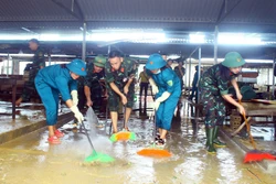 Lực lượng quân đội, dân quân tự vệ đẩy bùn đất, tổng dọn vệ sinh tại chợ xã Thanh Mỹ, huyện Thanh Chương (Nghệ An). Ảnh: Tá Chuyên - TTXVN