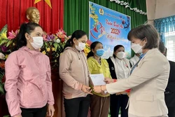 Bà Nguyễn Thị Bích Thủy, Phó Chủ tịch Thường trực Liên đoàn Lao động tỉnh Bình Định tặng quà Tết cho người lao động có hoàn cảnh đặc biệt khó khăn ở huyện Vân Canh (Bình Định). Ảnh: Nguyên Linh - TTXVN