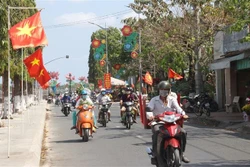 Các tuyến đường thành phố Vĩnh Long, tỉnh Vĩnh Long rực rỡ sắc Xuân chào đón năm mới. Ảnh: Lê Thúy Hằng - TTXVN