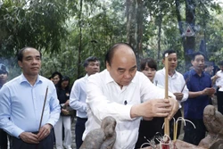 Chủ tịch nước Nguyễn Xuân Phúc cùng đoàn công tác dâng hương tưởng nhớ Chủ tịch Hồ Chí Minh tại Lán Nà Nưa trong Khu di tích lịch sử Quốc gia đặc biệt Tân Trào. Ảnh: Thống Nhất - TTXVN