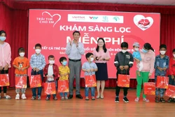 Bí thư Tỉnh ủy Sóc Trăng Lâm Văn Mẫn và đại diện Quỹ Chương trình Tấm lòng Việt trao quà cho trẻ có hoàn cảnh gia đình khó khăn. Ảnh: Trung Hiếu - TTXVN