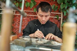 Trình diễn kỹ thuật nghề đậu bạc của nghệ nhân Quách Tuấn Anh (làng nghề kim hoàn Định Công) góp phần giữ gìn và phát huy bản sắc văn hóa truyền thống của dân tộc, quảng bá, tôn vinh những giá trị văn hóa của làng nghề Thủ đô. Ảnh: Thanh Tùng - TTXVN