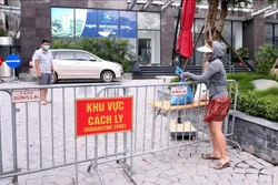 Người thân đưa đồ nhu yếu phẩm thiết yếu tiếp tế cho cư dân sống tại Toà chung cư Viễn Đông Star (số 1 phố Giáp Nhị, quận Hoàng Mai, Hà Nội) bị phong tỏa. Ảnh: Phạm Kiên - TTXVN