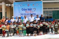 Ban tổ chức trao tặng đồ dùng học tập cho học sinh khó khăn xã Đăk Sơ Mei, huyện Đăk Đoa (Gia Lai). Ảnh: TTXVN phát