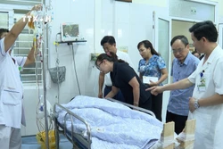 Phó Chủ tich UBND tỉnh Lào Cai Giàng Thị Dung thăm hỏi nạn nhân trong vụ tai nạn lao động đang được điều trị tại Bệnh viện đa khoa tỉnh Lào Cai. Ảnh: TTXVN phát