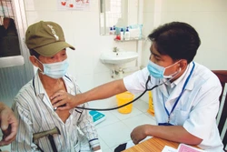 Bác sĩ Danh Ngọc Châu khám bệnh cho người dân có hoàn cảnh khó khăn tại phòng khám Trung tâm Y tế huyện Châu Thành. Ảnh: Hồng Đạt