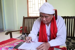 Cả sư Đổng Bạ biên tập các phong tục, nghi lễ truyền thống bằng tiếng Chăm. Ảnh: Nguyễn Thành