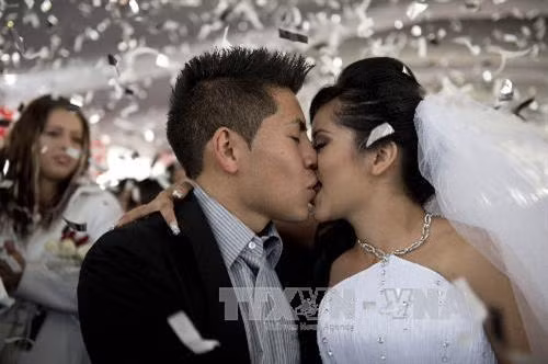 Ngày lễ Tình nhân Valentine 14/2 năm nay ở Mexico được cho là ngày hạnh phúc nhất đối với hàng ngàn cặp đôi khi có hơn 4500 cặp uyên ương đã tổ chức lễ thành hôn tập thể tại thủ đô Mexico City và bang Chihuahua của nước này. Tại Mexico City, khoảng 1500 cặp uyên ương đã tổ chức đám cưới tập thể trong khi hơn 3000 cặp uyên ương đã rất hạnh phúc trong đám cưới tập thể ở bang Chihuahua trong ngày lễ ý nghĩa này. Trong ảnh: Cô dâu, chú rể hạnh phúc trong lễ cưới tập thể ở Mexico City. AFP/TTXVN