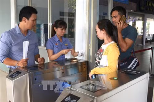 Hướng dẫn hành khách tại cổng soát vé tự động. Ảnh: Trần Xuân Tình-TTXVN Hướng dẫn hành khách tại cổng soát vé tự động. Ảnh: Trần Xuân Tình-TTXVN